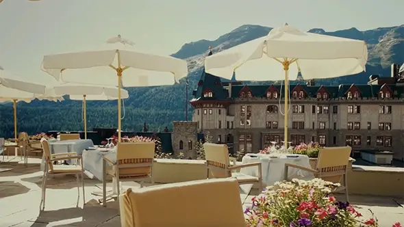 La Diala restaurant terrace at Badrutt’s Palace in summer with views of the historic building and mountains.