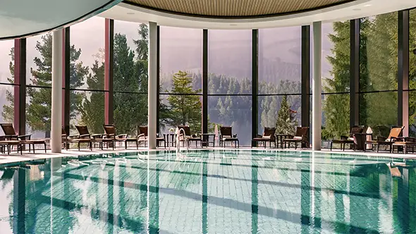 The panoramic indoor infinity pool at Palace Wellness featuring views of the Engadin forests and mountains.