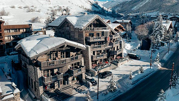 Authentic facade of Le K2 Chogori in Val d’Isère: snow-covered terraces and cozy alpine atmosphere in February