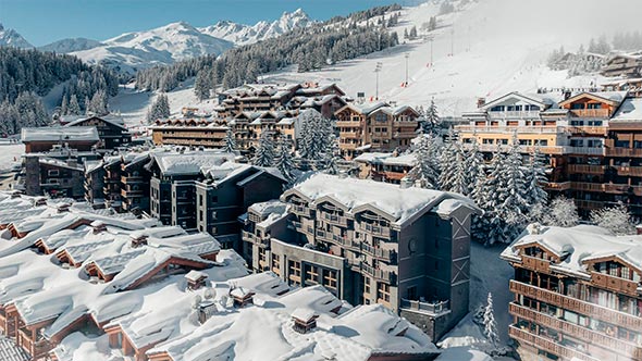 Winter panorama of Courchevel 1850 in February: snow-covered chalets and majestic Alps