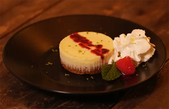 Dessert at Pom Thai Delicate cheesecake with raspberry sauce and fresh berries — an exquisite end to the dinner.