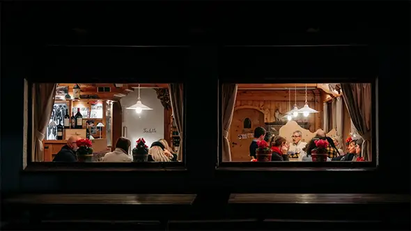 Evening view through the windows of the cozy Michelin-starred SanBrite restaurant in Cortina.