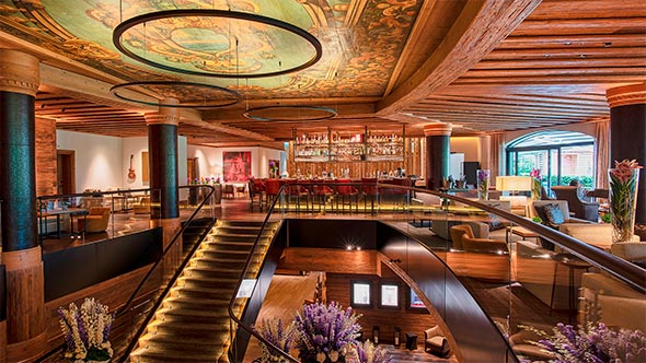 Elegant lounge bar interior at The Alpina Gstaad with painted ceiling and wooden columns