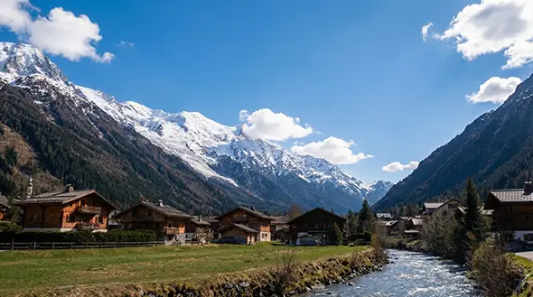 Wooden chalets by the river in a mountain village under a blue sky