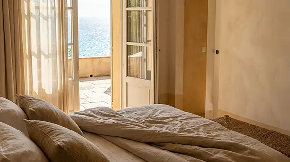 Bright bedroom of a luxury suite with terrace access.