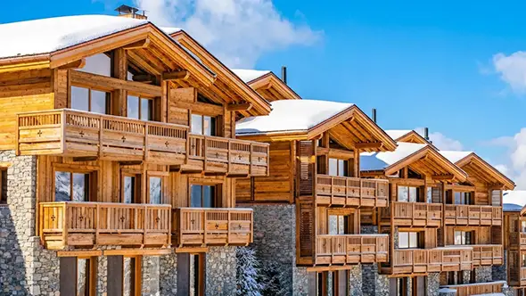 Architecture of Ultima Courchevel residences, combining traditional wood and natural stone.
