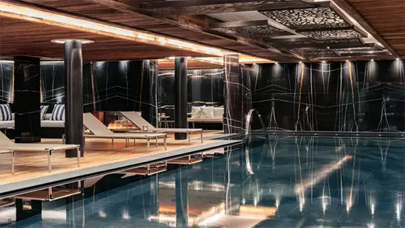 Luxury spa area at Ultima Gstaad featuring a large heated swimming pool and modern design.