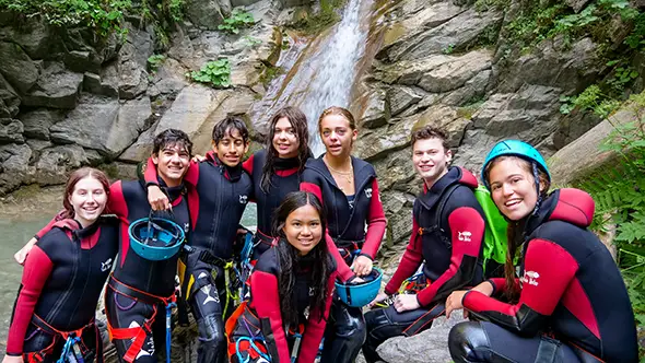 Canyoning by a waterfall at camp