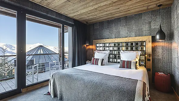 Bedroom with a mirrored headboard and balcony.