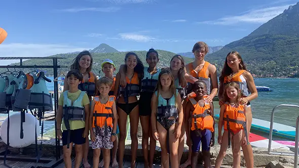 Kids in life jackets by water