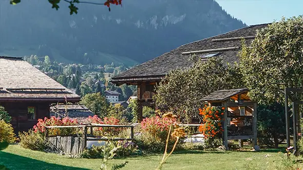 Traditional wooden chalet with blooming garden at Les Fermes de Marie.