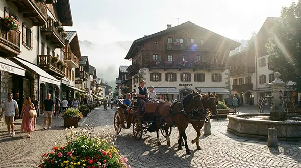 Horse-drawn carriage on a cozy cobbled street in summer Megeve.