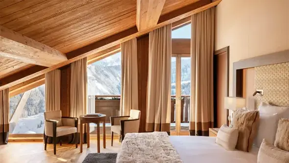 Cozy suite at Fouquets Courchevel hotel with a snowy Alps view.