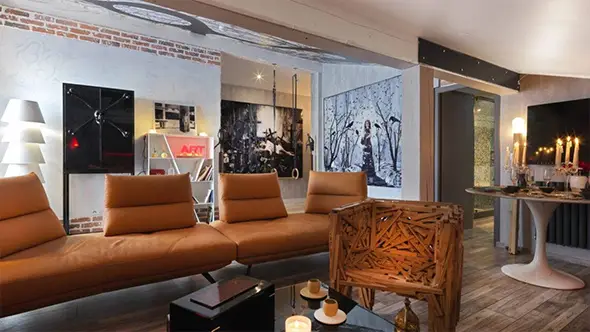 Living room with a leather sofa, swings, and art objects.