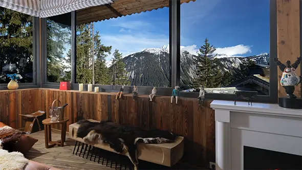 Panoramic view of snow-capped mountains from a wooden room window.