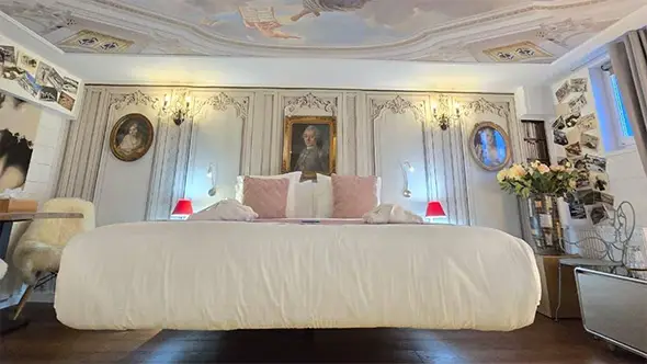Floating bed and ceiling fresco in room 2 of Snow Lodge hotel.
