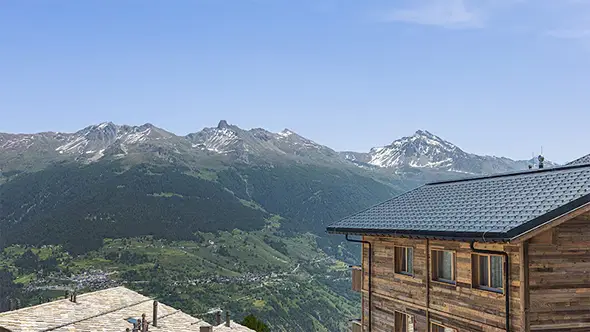 Traditional wooden chalet overlooking an alpine valley.