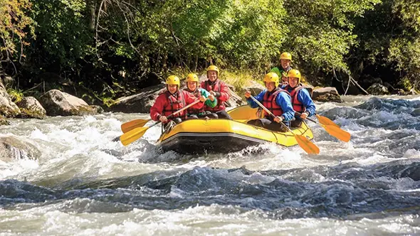 Corporate team building during whitewater rafting in the Alps.