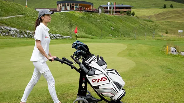 Woman with a golf cart on a golf course in Lech.