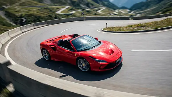 Red Ferrari F8 Spider on an Alpine mountain pass.