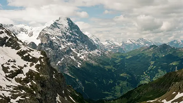 Panoramic view of the Swiss Alps and valley from Glacier 3000 peak.