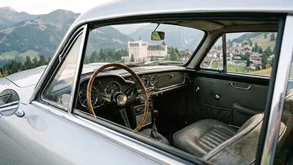 View from a vintage car towards Gstaad Palace hotel in the Alps.