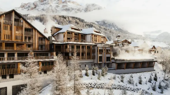 Aman Rosa Alpina exterior under fresh snow with the Dolomite peaks behind