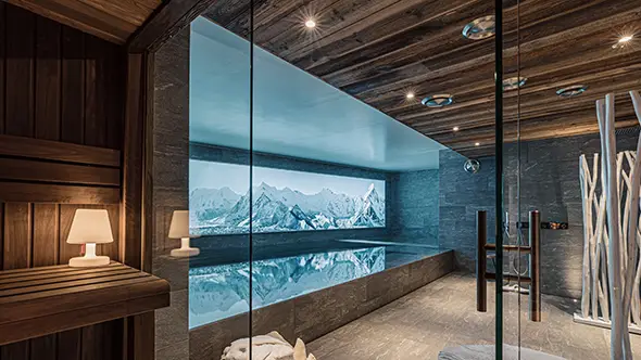 Indoor pool with mountain view in chalet Orca spa.