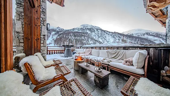Spacious terrace with sofas and fire pit at chalet Orso in Val dIsere