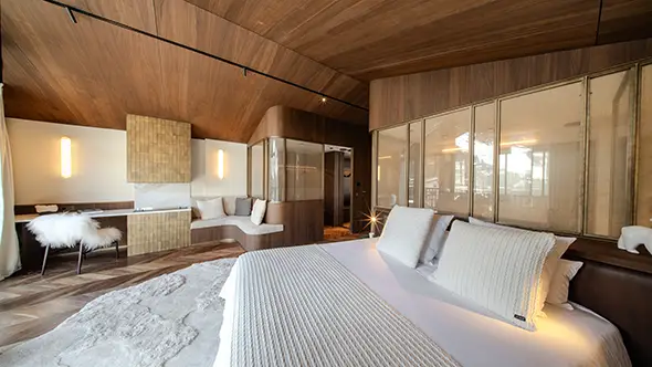 Master bedroom with wooden finishes and workspace in Chalet Cristal