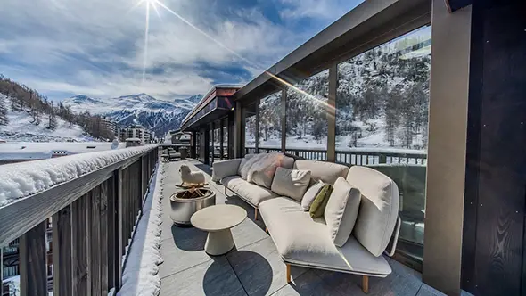 North terrace with comfortable sofas and views of the snow-covered mountains