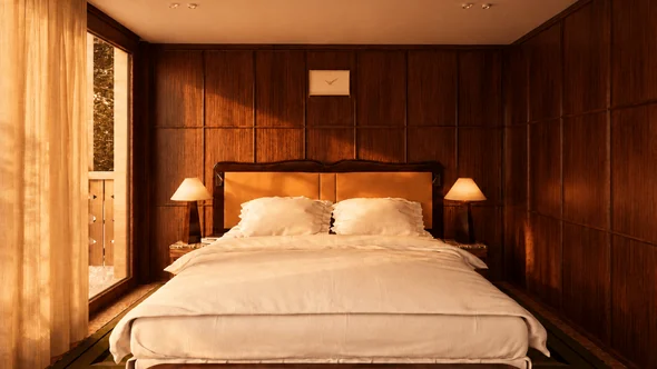 Panelled bedroom with an upholstered headboard and twin bedside lamps at Bourbon Hotel Courchevel 1850