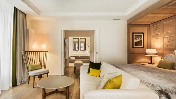 Junior Suite Mont-Blanc with a sitting area, a round table and a panelled bed wall at Hôtel Mont-Blanc Chamonix