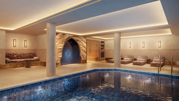 Indoor mosaic pool beneath an Ottoman arch with patterned loungers at the Le Saint Roch spa