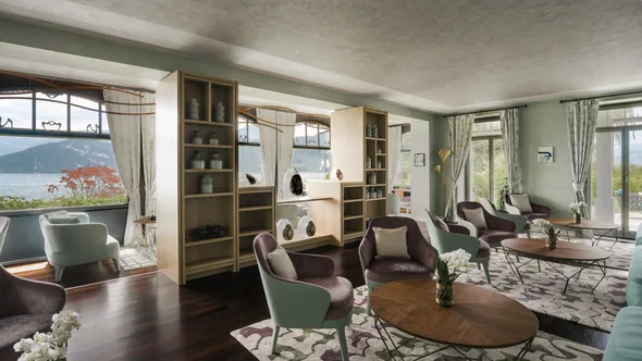 A lounge at Chenot Palace Weggis with armchairs, shelves and windows onto Lake Lucerne