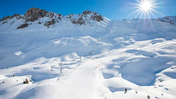Wide groomed pistes above Courchevel 1850 under a clear winter sky