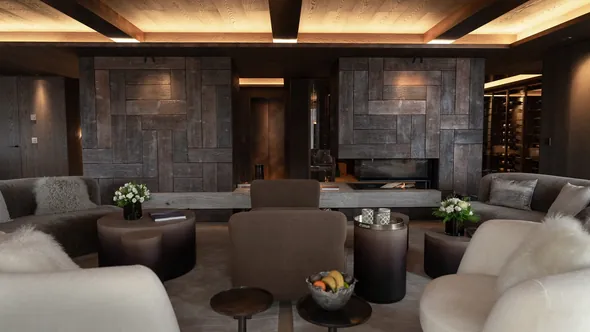 Living room at No. 14 Verbier with sofas grouped around a fireplace set in a stone wall