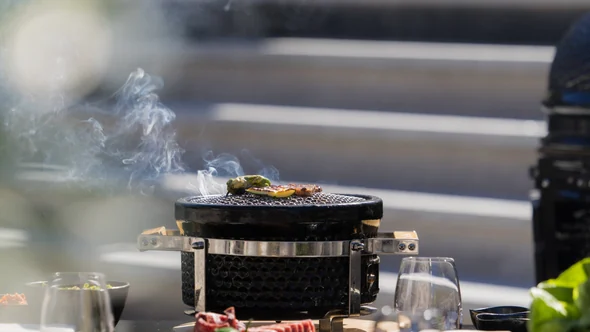 Yakiniku grill smoking on a terrace table above the Courchevel slopes at lunchtime