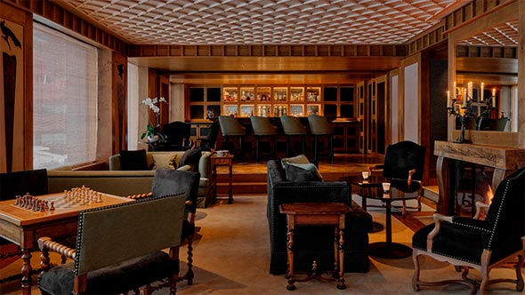 Cozy lounge with a fireplace and bar at Aman Le M&eacute;l&eacute;zin hotel for evening relaxation. / Уютная гостиная с камином и баром в отеле Aman Le M&eacute;l&eacute;zin для вечернего отдыха.
