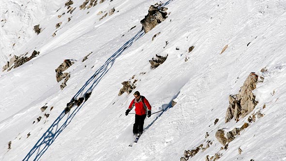 An experienced skier descending a steep slope in Courchevel near the Aman Le Melezin hotel