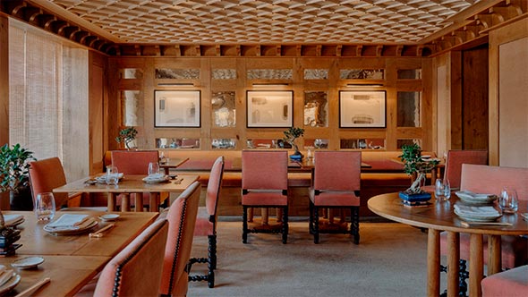 The interior of Nama Japanese restaurant at Aman Le M&eacute;l&eacute;zin featuring oak paneling and minimalist aesthetics. / Интерьер японского ресторана Nama в отеле Aman Le M&eacute;l&eacute;zin с дубовыми панелями и эстетикой минимализма.