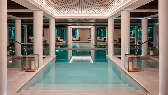 The 14-meter swimming pool at Aman Spa, surrounded by stone columns for deep relaxation. / 14-метровый бассейн в Aman Spa, окруженный каменными колоннами для глубокого расслабления.