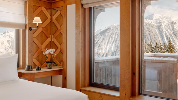 A view of the snow-capped mountains from the panoramic window of a cozy suite at Aman Le M&eacute;l&eacute;zin. / Вид на заснеженные горы из панорамного окна уютного номера в отеле Aman Le M&eacute;l&eacute;zin.