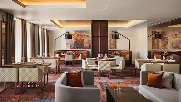 Stylish interior of the Steak House by Viceroy restaurant featuring soft seating, modern artwork, and cozy tables for an evening gala dinner.