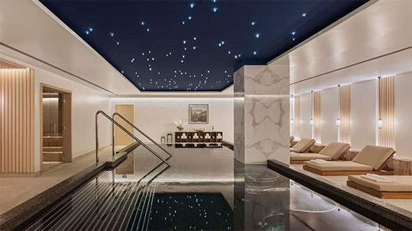 Interior of The Spa by Viceroy featuring an indoor pool with a starlit ceiling and a relaxation area with sun loungers.