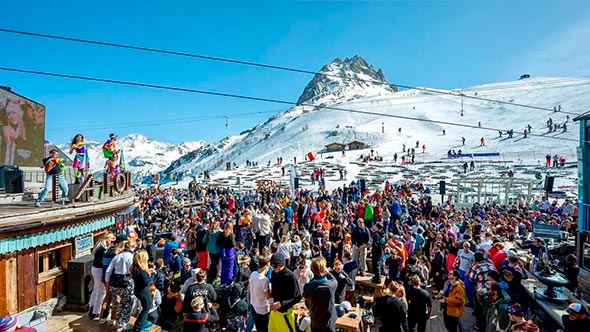 A large-scale apres-ski party at La Folie Douce on an open terrace overlooking the mountains in Courchevel.