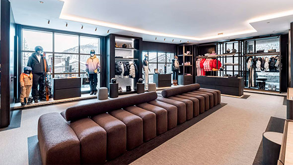 Interior of the luxurious Le K2 ski wear and equipment boutique, featuring modern seating and panoramic windows overlooking the snowy slopes.