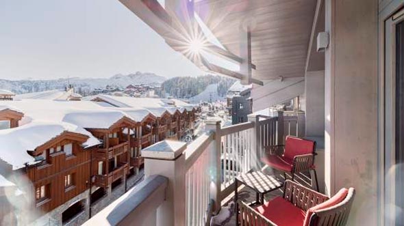 View from a sunny balcony of a suite at Le K2 Djola hotel overlooking the snowy Alps and Courchevel 1850 resort. / Вид с солнечного балкона номера в отеле Le K2 Djola на заснеженные Альпы и курорт Куршевель 1850.