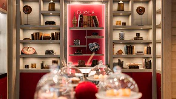 Cozy interior of Le K2 Djola hotel featuring a library and a dedicated area for afternoon Tea Time. / Уютный интерьер отеля Le K2 Djola с библиотекой и зоной для послеобеденного чаепития Tea Time.