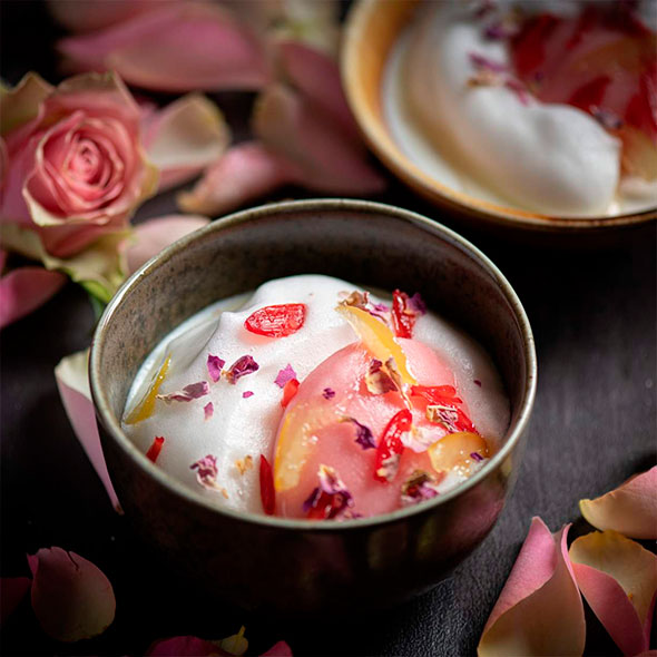 Exquisite dish with truffles and cream, served in a dark bowl on an artichoke base, with whole truffles nearby.